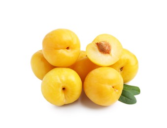 Photo of Whole and cut yellow cherry plums with leaves isolated on white
