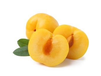 Photo of Whole and cut yellow cherry plums with leaves isolated on white