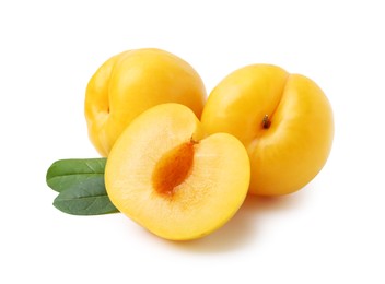 Photo of Whole and cut yellow cherry plums with leaves isolated on white
