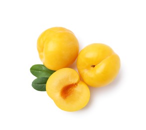 Photo of Whole and cut yellow cherry plums isolated on white, top view