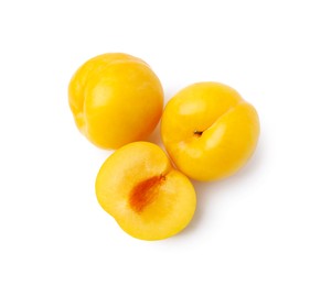 Photo of Whole and cut yellow cherry plums isolated on white, top view
