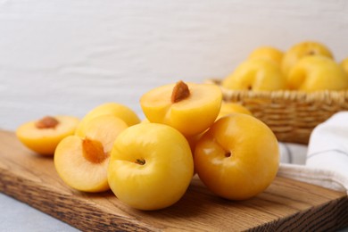 Photo of Ripe yellow cherry plums on grey table, closeup
