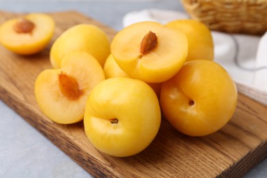 Photo of Ripe yellow cherry plums on grey table, closeup