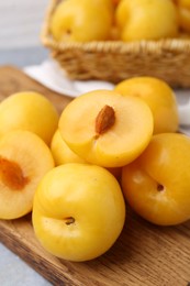 Photo of Ripe yellow cherry plums on grey table, closeup