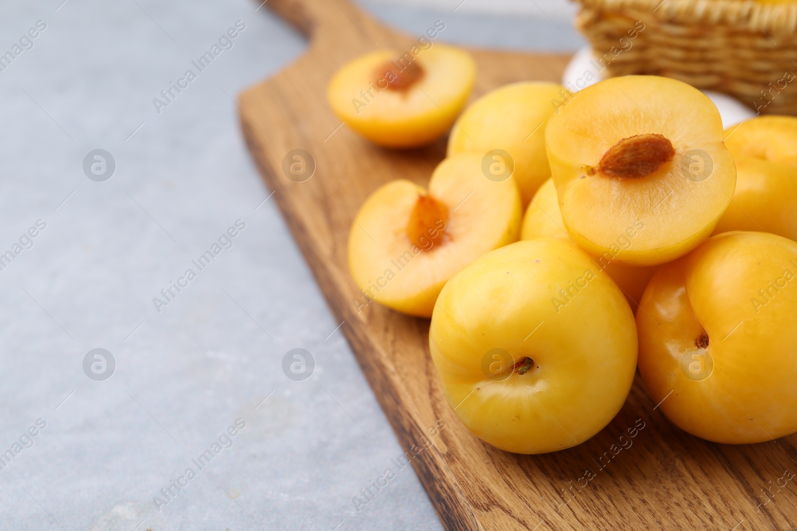 Ripe yellow cherry plums on grey table, closeup. Space for text Photo of Ripe yellow cherry plums on grey table, closeup. Space for text