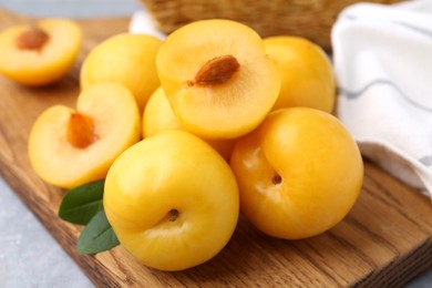 Photo of Ripe yellow cherry plums on grey table, closeup