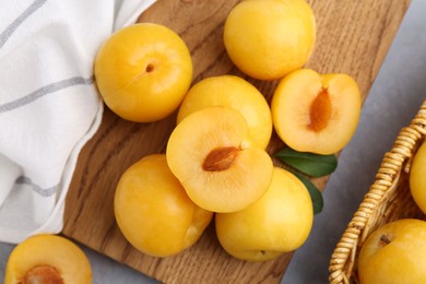 Photo of Ripe yellow cherry plums on grey table, flat lay
