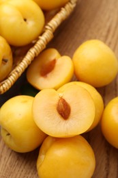 Photo of Ripe yellow cherry plums on wooden board, closeup