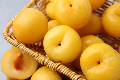 Photo of Ripe yellow cherry plums on grey table, closeup