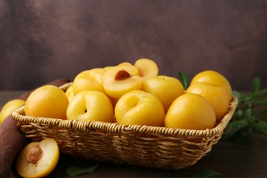 Photo of Ripe yellow cherry plums on wooden table, closeup. Space for text