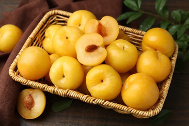 Photo of Ripe yellow cherry plums on wooden table, closeup