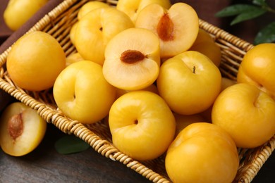 Photo of Ripe yellow cherry plums on wooden table, closeup