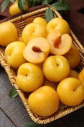 Photo of Ripe yellow cherry plums on wooden table, closeup