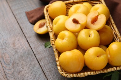 Photo of Ripe yellow cherry plums on wooden table, closeup. Space for text