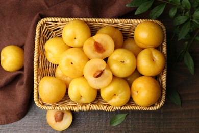 Photo of Ripe yellow cherry plums on wooden table, flat lay