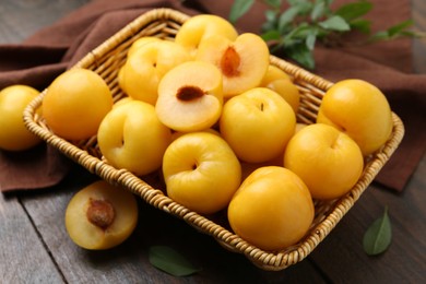 Photo of Ripe yellow cherry plums on wooden table, closeup