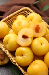 Photo of Ripe yellow cherry plums on wooden table, closeup