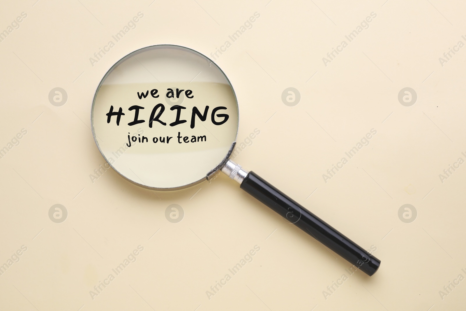Image of We are hiring, join our team. Inscription and magnifying glass on beige background, top view
