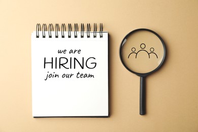 Image of We are hiring, join our team. Notebook with inscription and magnifying glass on beige background, top view