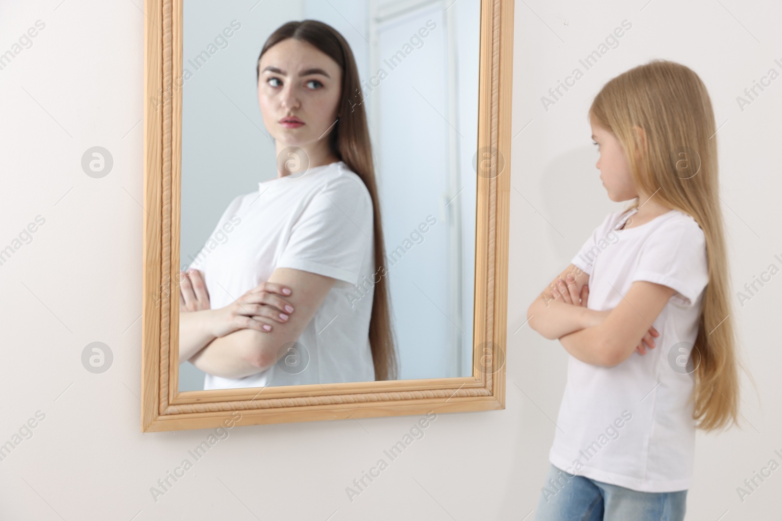 Little girl seeing herself as young woman in mirror. Conceptual collage about past and future, flow of time, age Image of Little girl seeing herself as young woman in mirror. Conceptual collage about past and future, flow of time, age