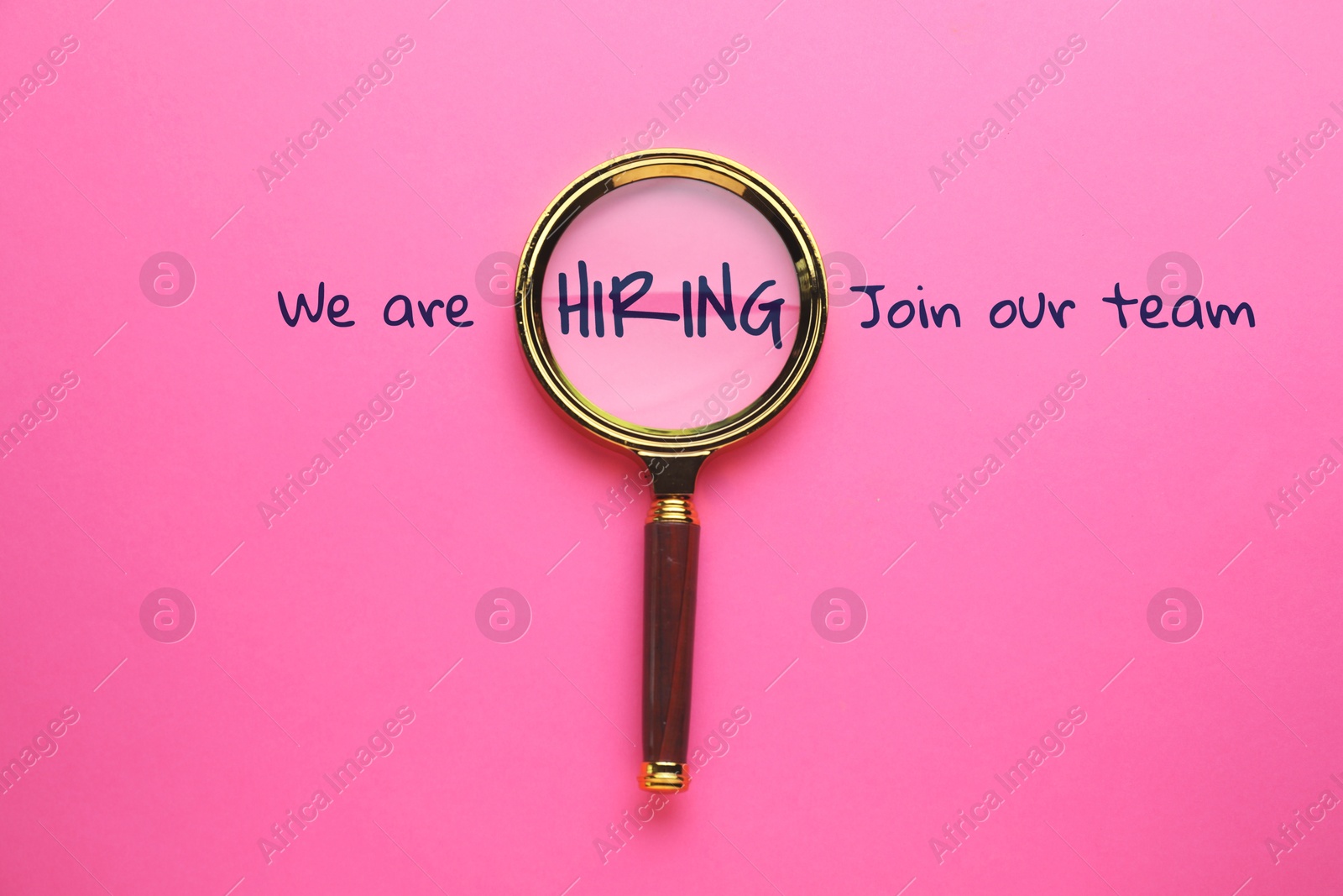 We are hiring, join our team. Inscription and magnifying glass on pink background, top view Image of We are hiring, join our team. Inscription and magnifying glass on pink background, top view