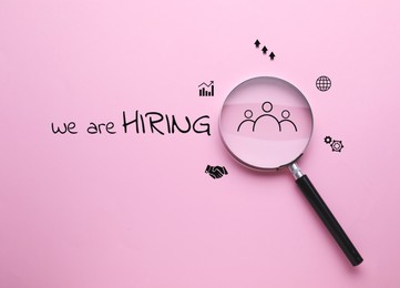 Image of We are hiring. Inscription, icons and magnifying glass on pink background, top view