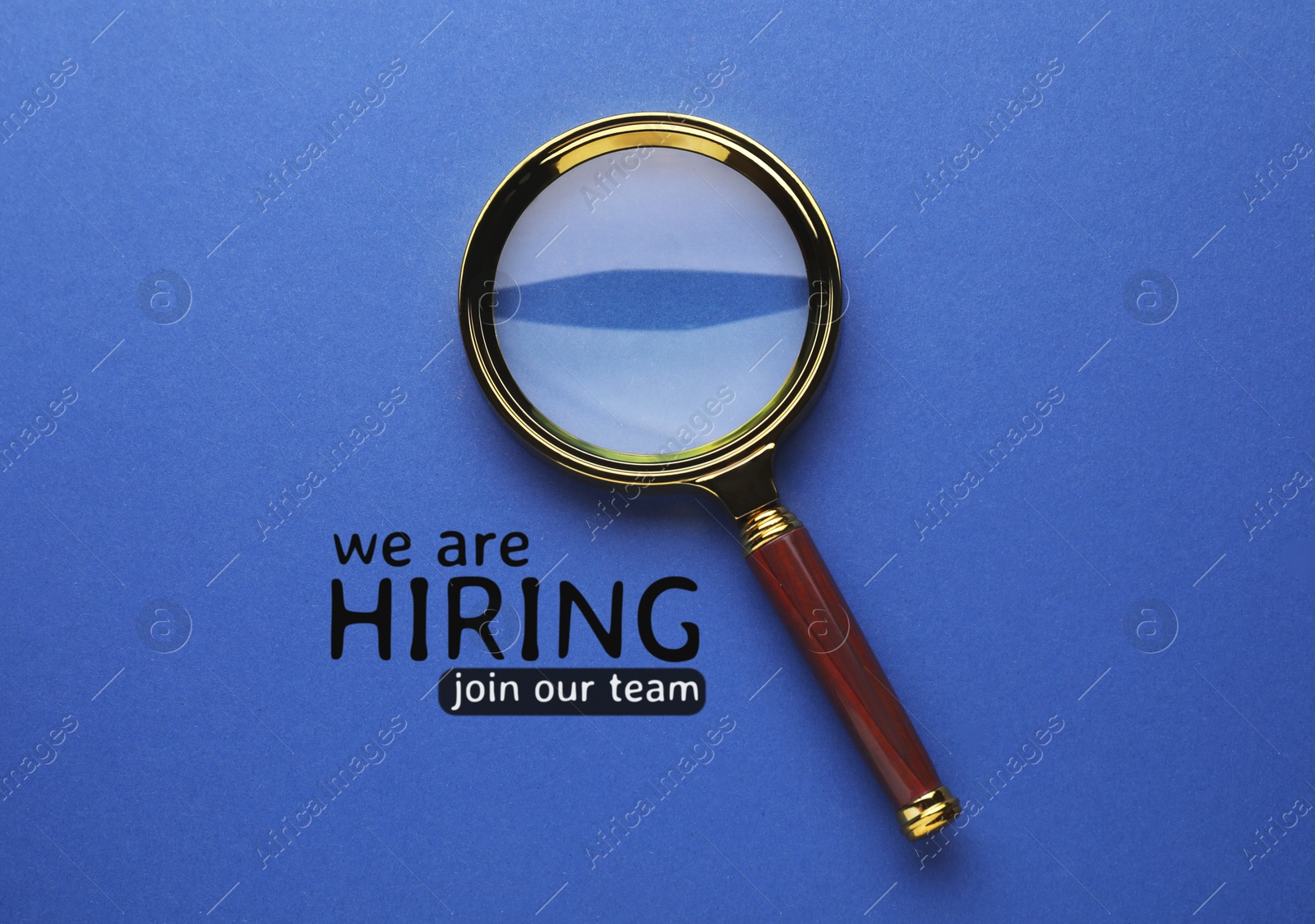 Image of We are hiring, join our team. Inscription and magnifying glass on blue background, top view