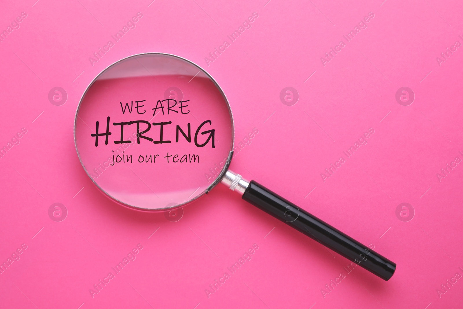 We are hiring, join our team. Inscription and magnifying glass on pink background, top view Image of We are hiring, join our team. Inscription and magnifying glass on pink background, top view