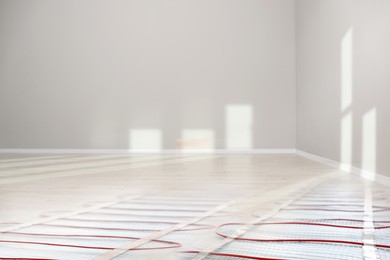 Image of Underfloor heating system, double exposure with laminate floor in room