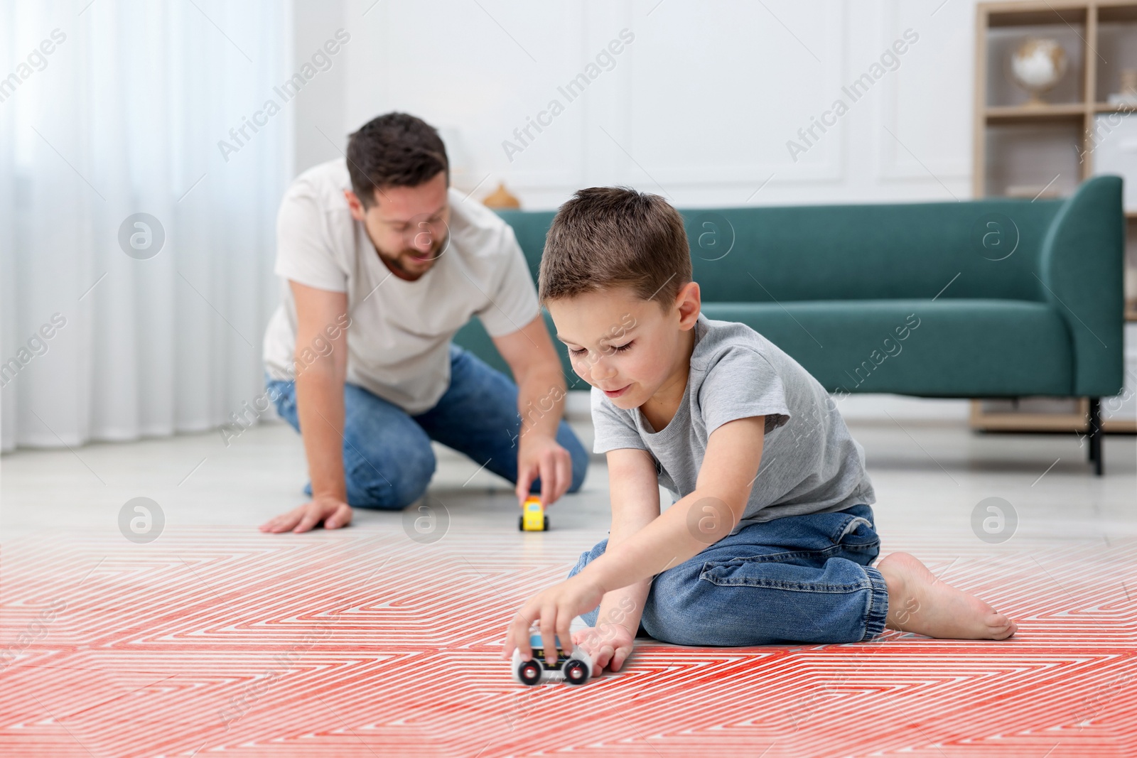 Father and son playing on warm floor at home, double exposure with underfloor heating system Image of Father and son playing on warm floor at home, double exposure with underfloor heating system