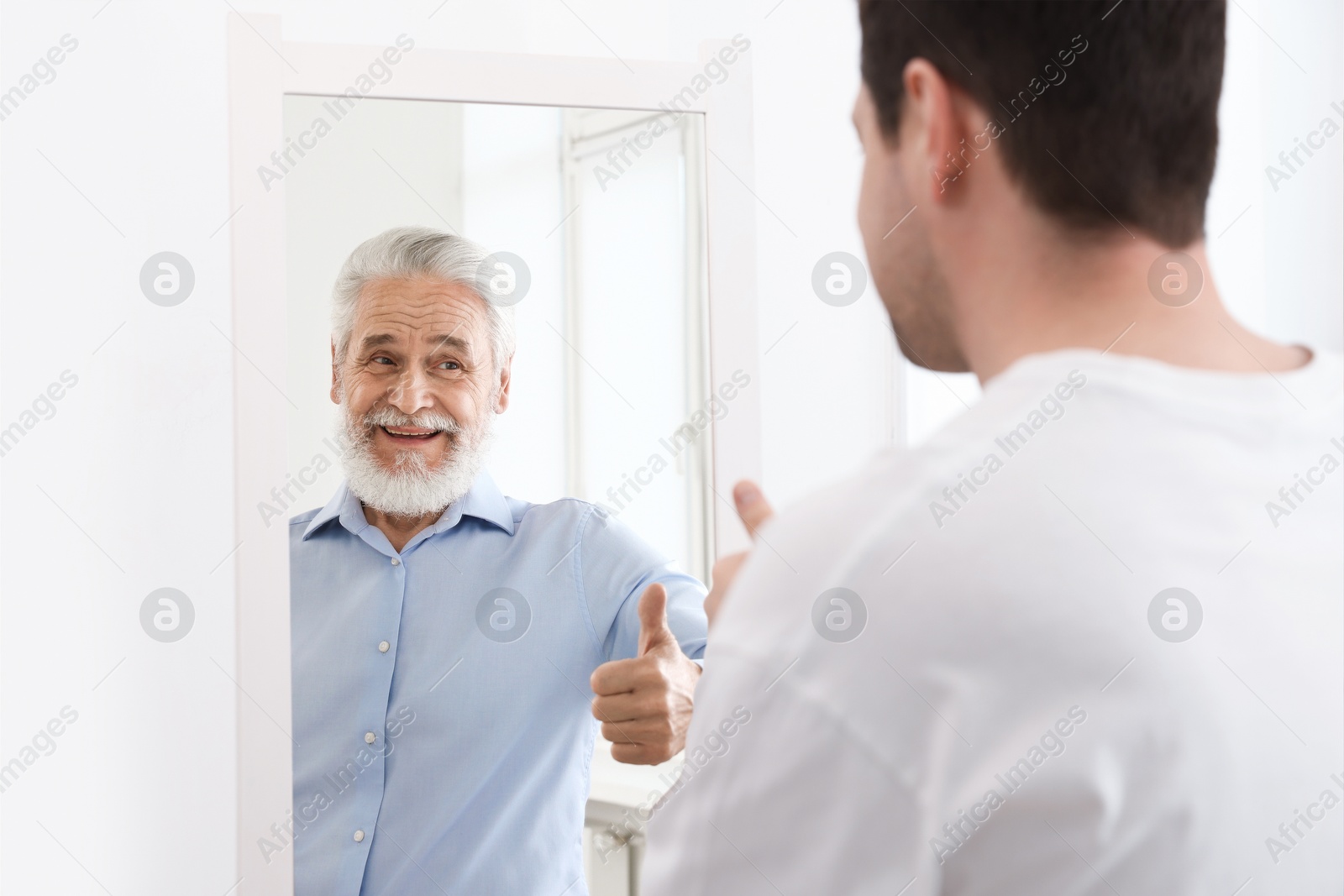 Man seeing himself as elder in mirror. Conceptual collage about past and future, flow of time, age Image of Man seeing himself as elder in mirror. Conceptual collage about past and future, flow of time, age