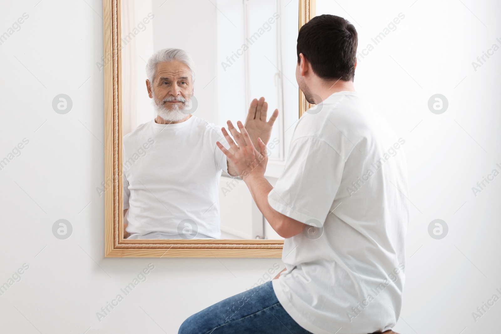 Man seeing himself as elder in mirror. Conceptual collage about past and future, flow of time, age Image of Man seeing himself as elder in mirror. Conceptual collage about past and future, flow of time, age