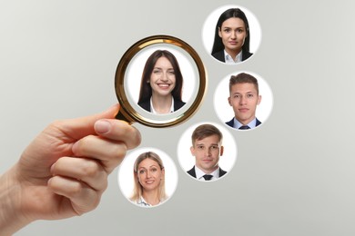 Image of Recruiter looking at candidate's photo through magnifying glass on light grey background, closeup. Human resources management