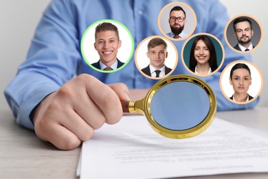 Image of Recruiter with magnifying glass and candidates' photos at table, closeup. Human resources management