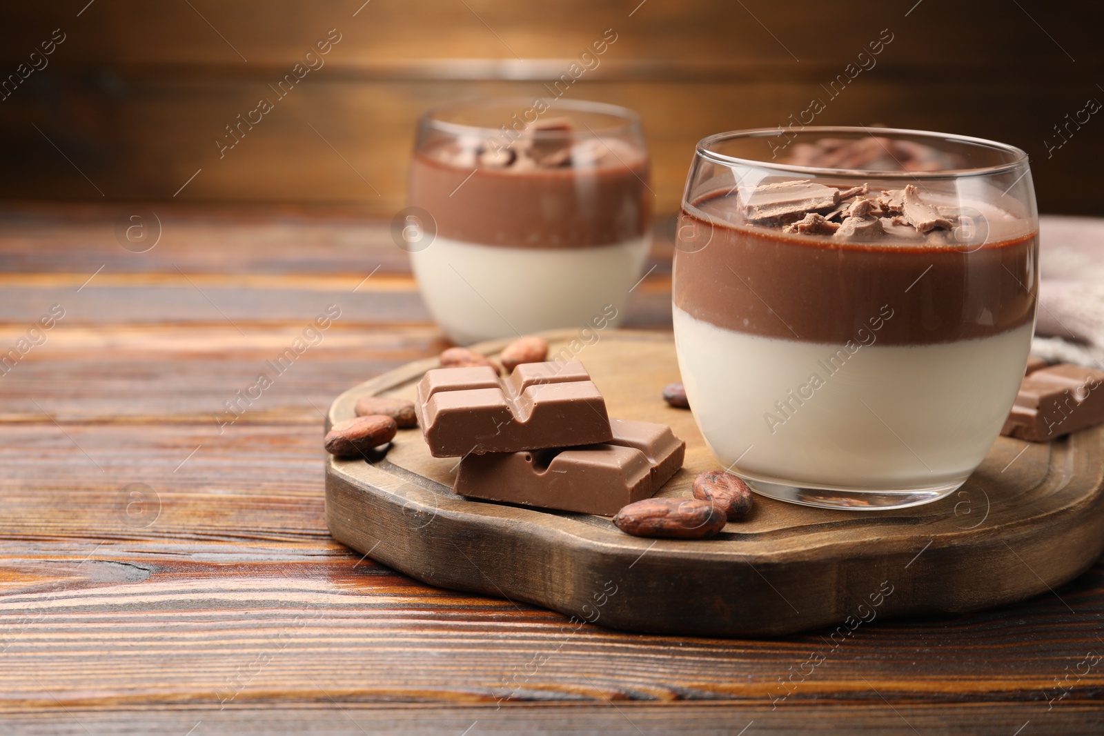 Photo of Delicious panna cotta with chocolate and cocoa beans on wooden table, closeup. Space for text