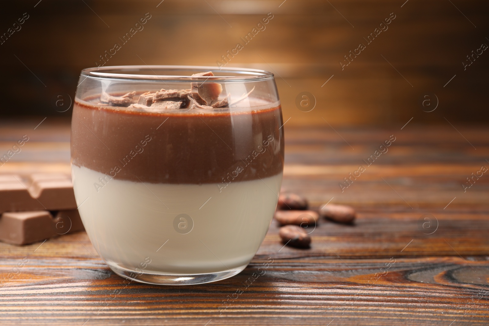 Photo of Delicious panna cotta with chocolate on wooden table, closeup. Space for text