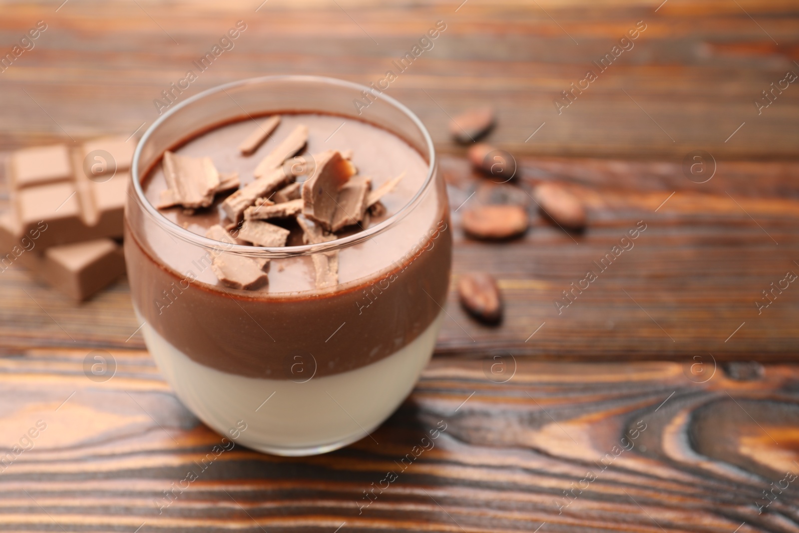 Photo of Delicious panna cotta with chocolate on wooden table, closeup. Space for text