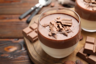 Photo of Delicious chocolate panna cotta in glasses on wooden table, closeup