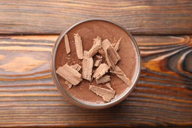 Photo of Delicious chocolate panna cotta in glass on wooden table, top view