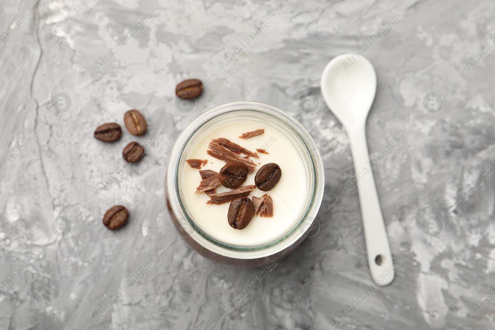 Delicious panna cotta with chocolate chunks and coffee beans on grey textured table, flat lay Photo of Delicious panna cotta with chocolate chunks and coffee beans on grey textured table, flat lay