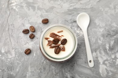 Photo of Delicious panna cotta with chocolate chunks and coffee beans on grey textured table, flat lay