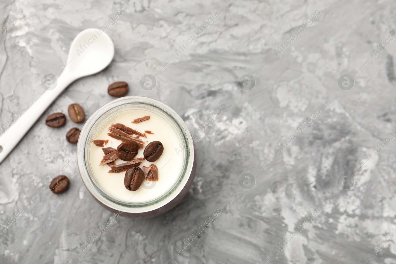 Delicious panna cotta with chocolate chunks and coffee beans on grey textured table, flat lay. Space for text Photo of Delicious panna cotta with chocolate chunks and coffee beans on grey textured table, flat lay. Space for text