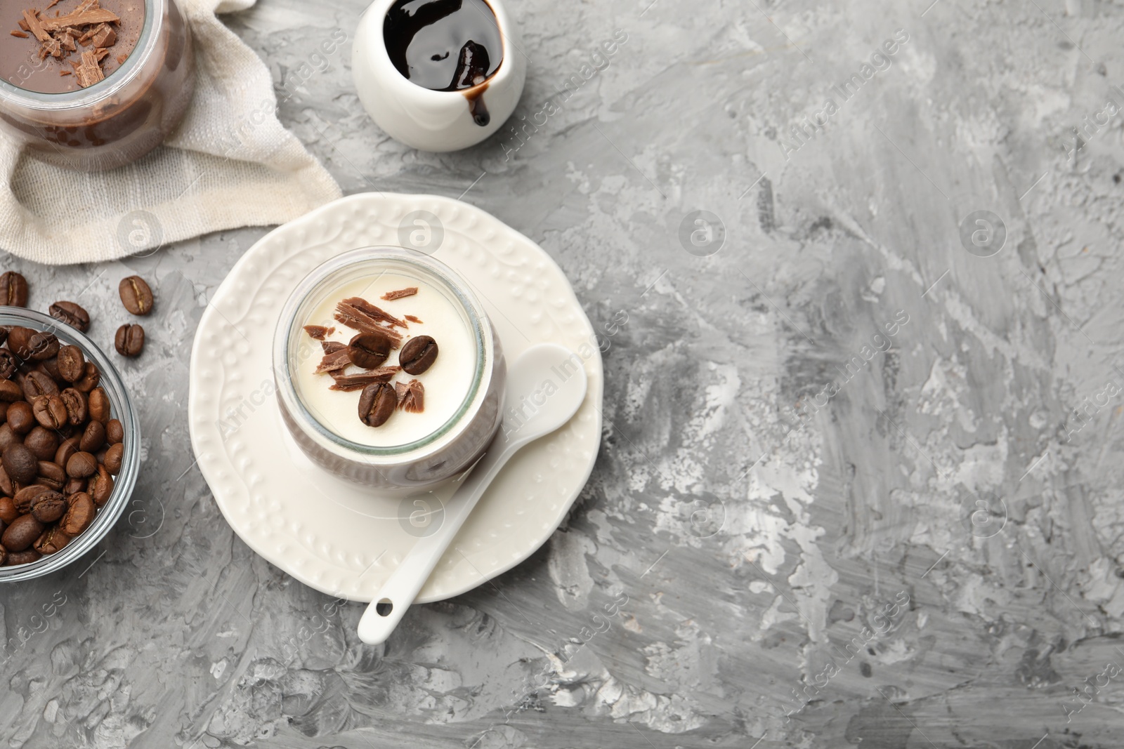 Delicious panna cotta with chocolate chunks and coffee beans served on grey textured table, flat lay. Space for text Photo of Delicious panna cotta with chocolate chunks and coffee beans served on grey textured table, flat lay. Space for text