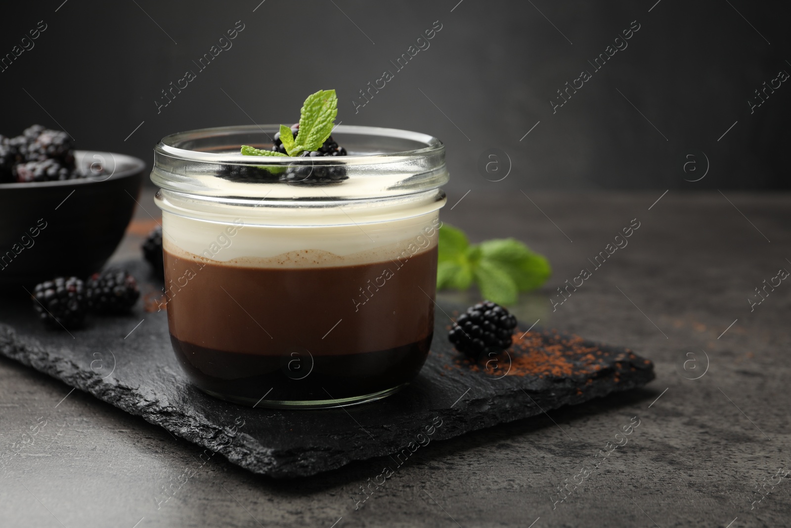 Tasty panna cotta with blackberries and mint in jar at grey table, closeup. Space for text Photo of Tasty panna cotta with blackberries and mint in jar at grey table, closeup. Space for text