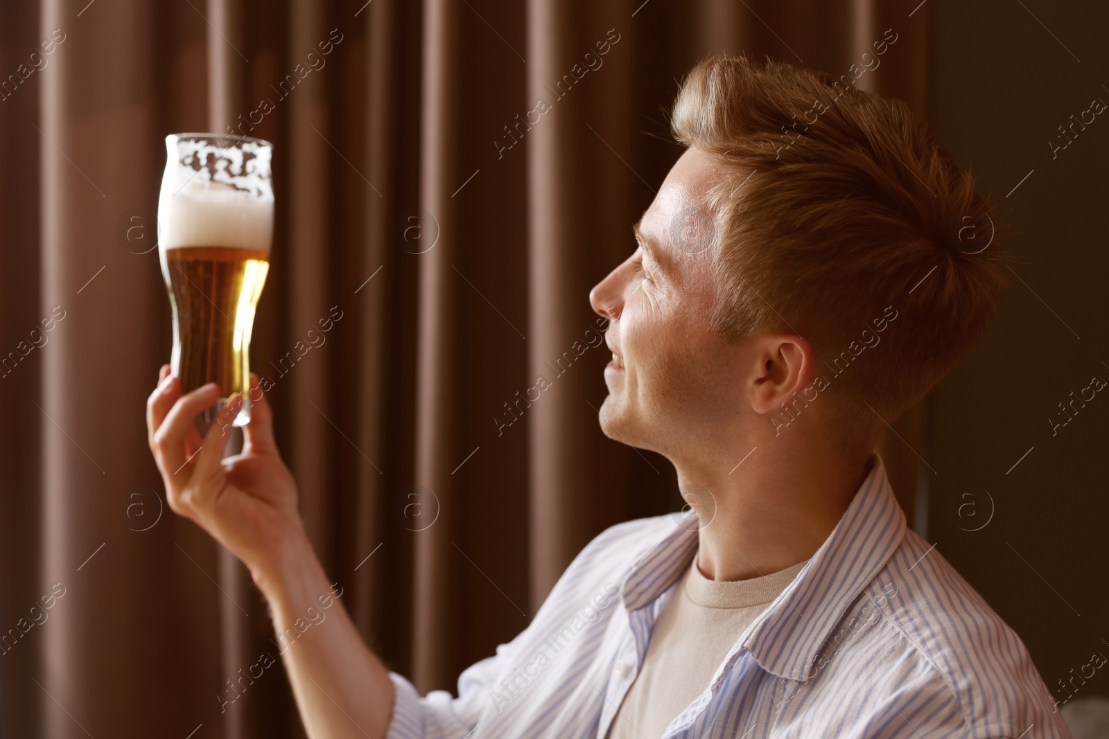 Photo of Young man with glass of beer in bar