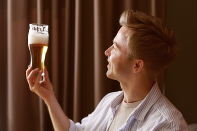 Photo of Young man with glass of beer in bar