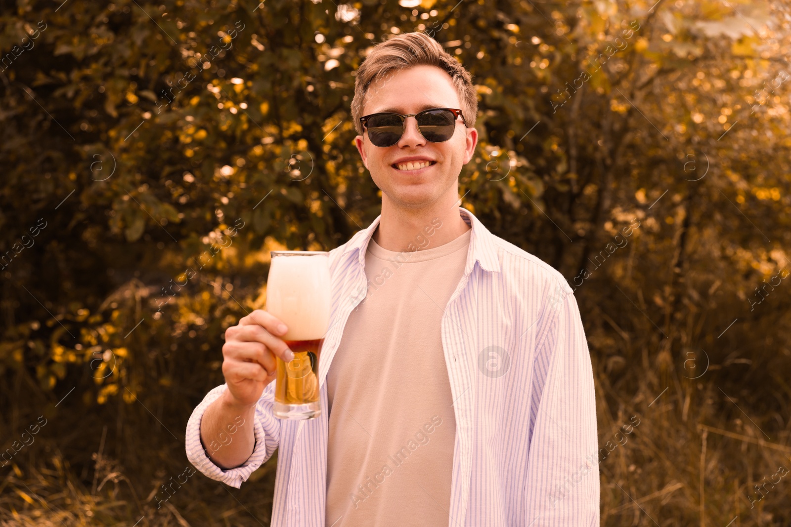 Photo of Young man with glass of beer outdoors