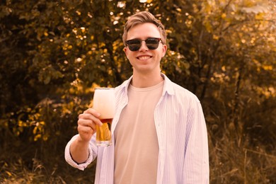 Photo of Young man with glass of beer outdoors