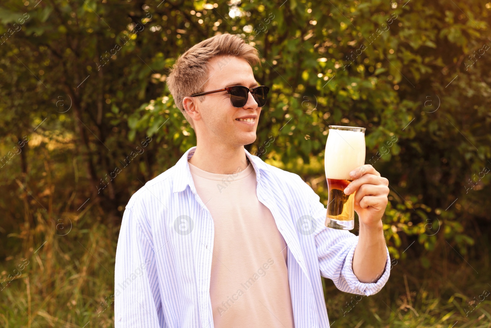 Photo of Young man with glass of beer outdoors
