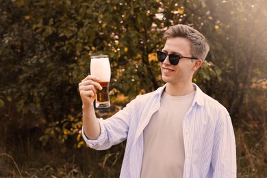 Photo of Young man with glass of beer outdoors